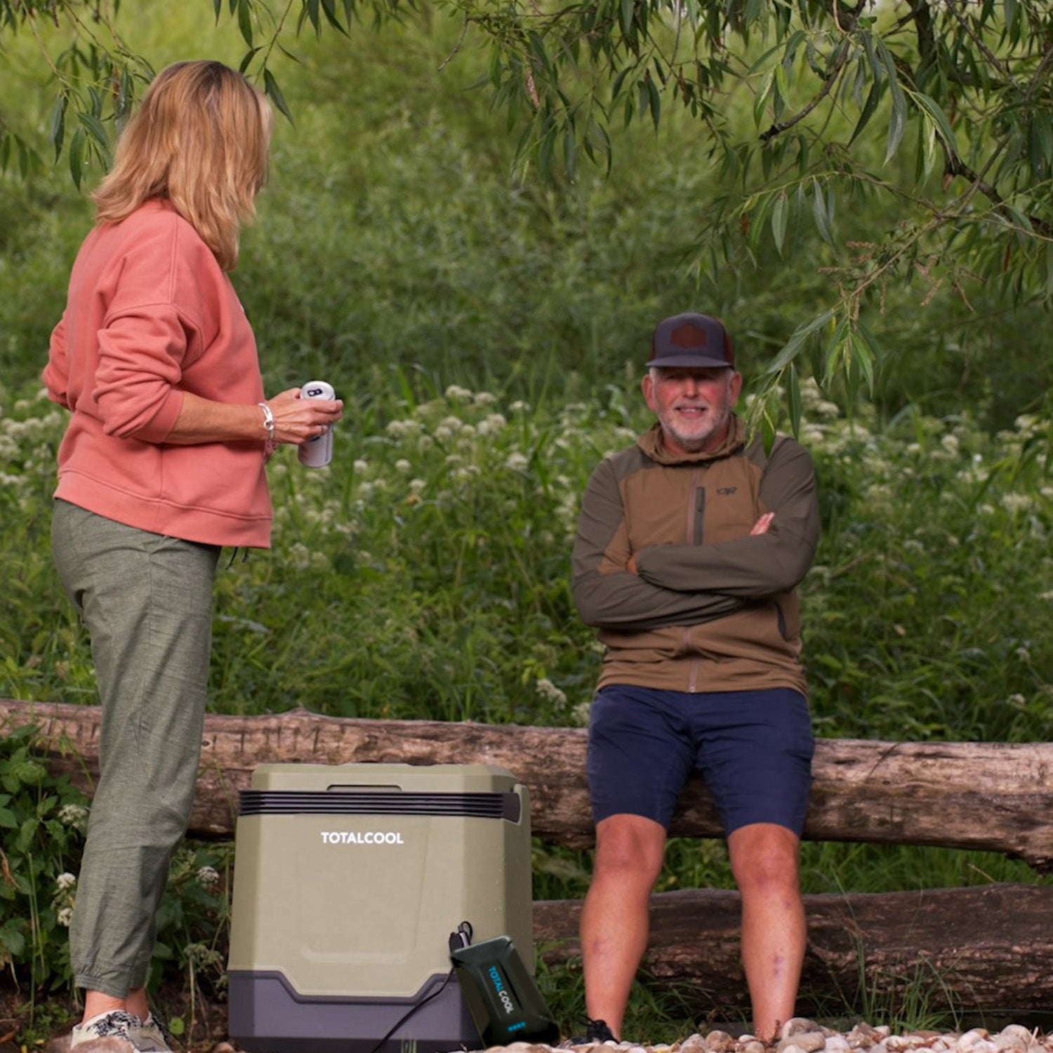 Image of a man and woman taking their Eco-Chill 33 Green coolbox on an outing whilst powering it with a TP144