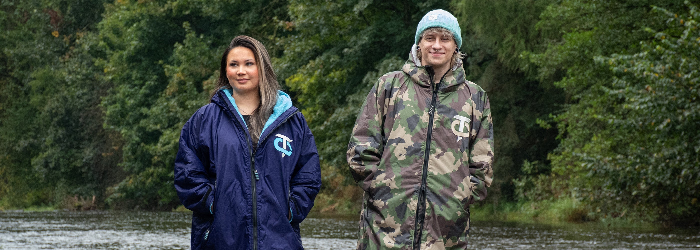 Image of a man wearing a camo and grey T-Robe outdoors alongside a woman wearing a deep purple and blue T-Robe