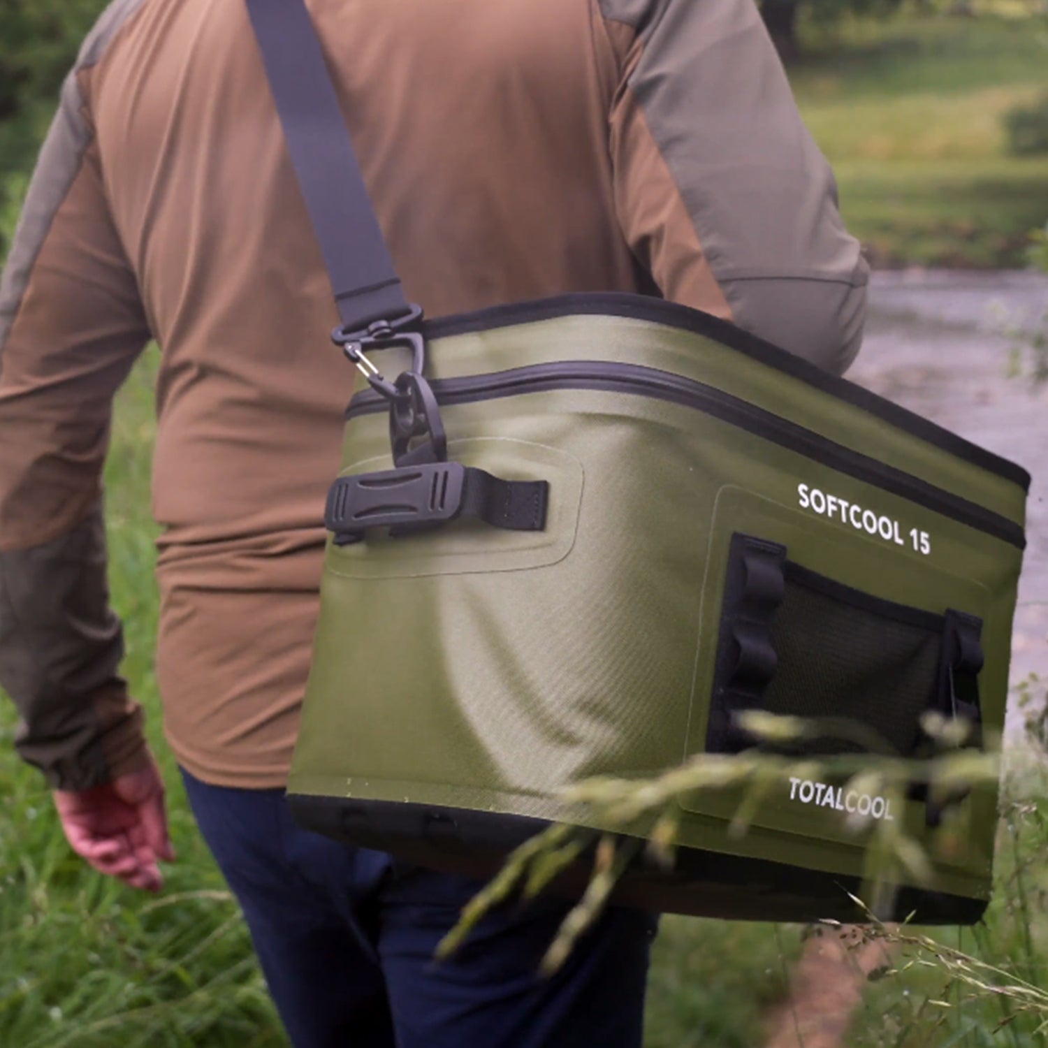 Image of the green Softcool 15 coolbox being carried through woodlands