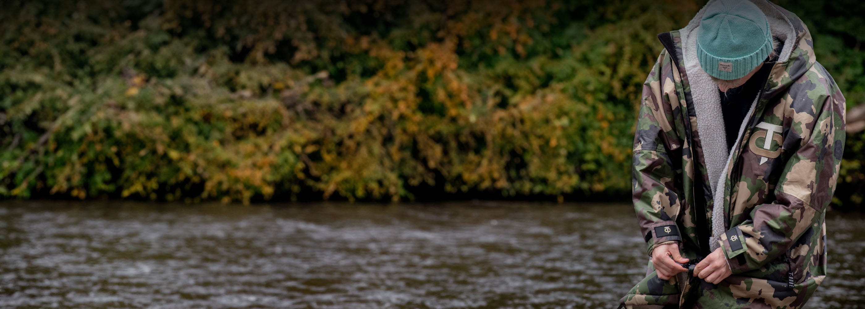 Image of a man wearing a camo T-Robe weatherproof changing robe whilst zipping it up