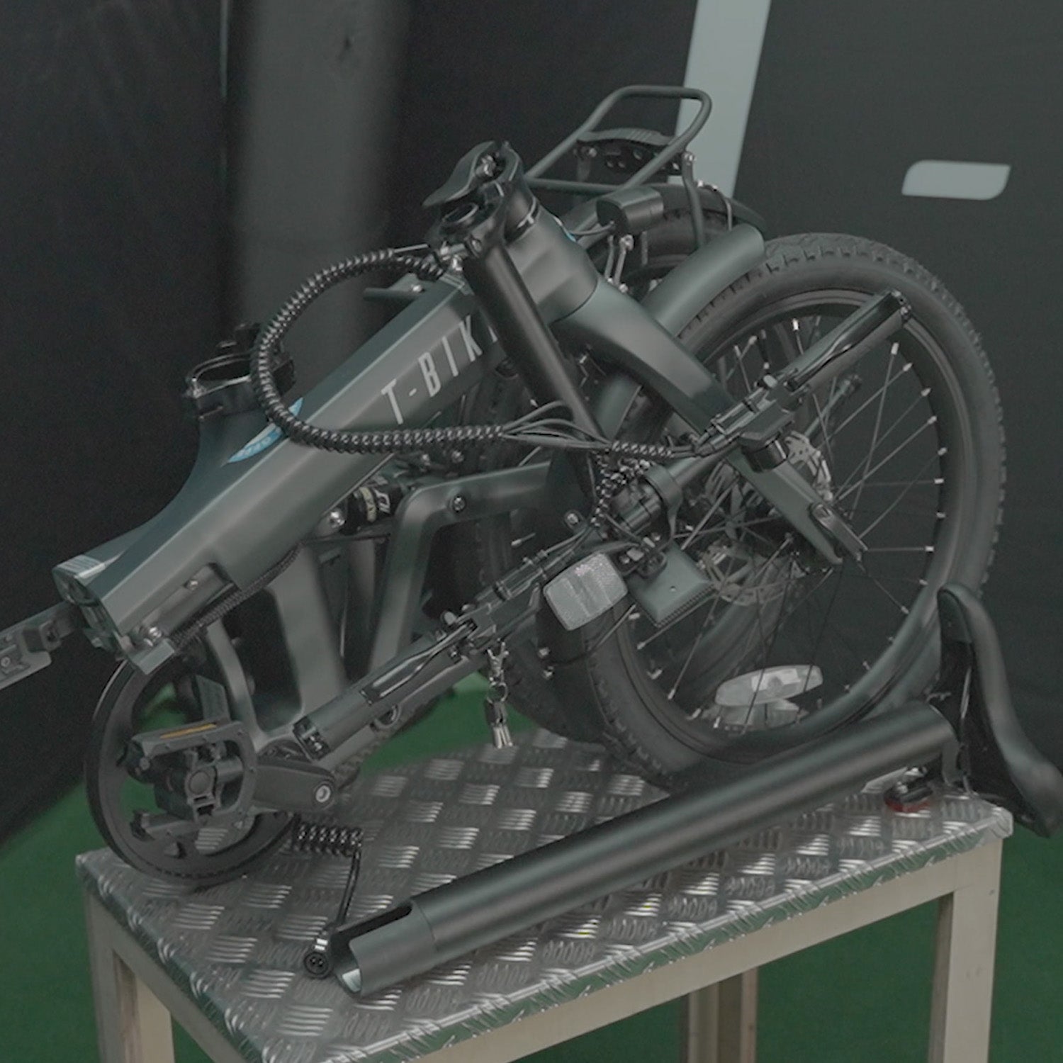 Image of the CF250 Folding carbon fibre E-Bike in matt grey folded and placed on a small table