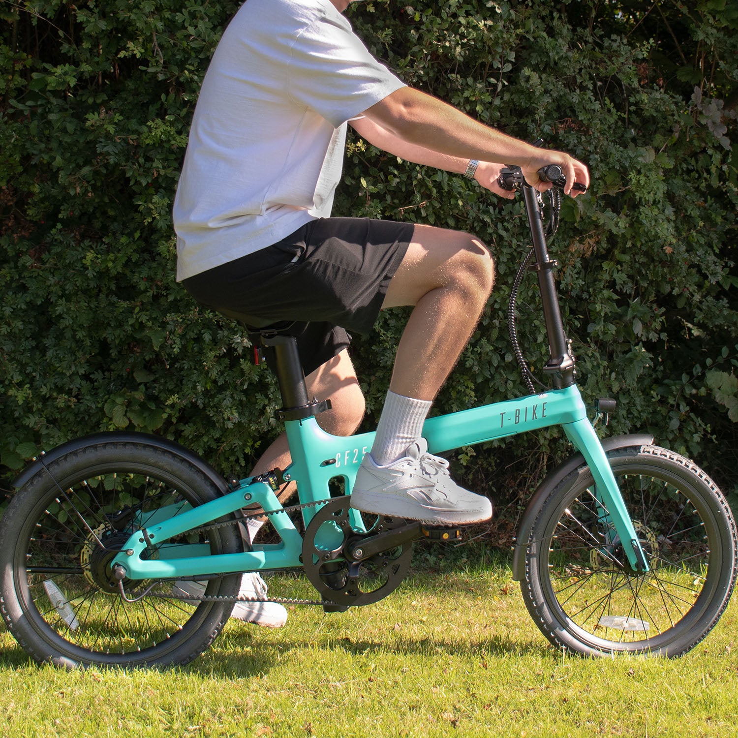 Image of the CF250 Folding carbon fibre E-Bike in turquoise being used on grass