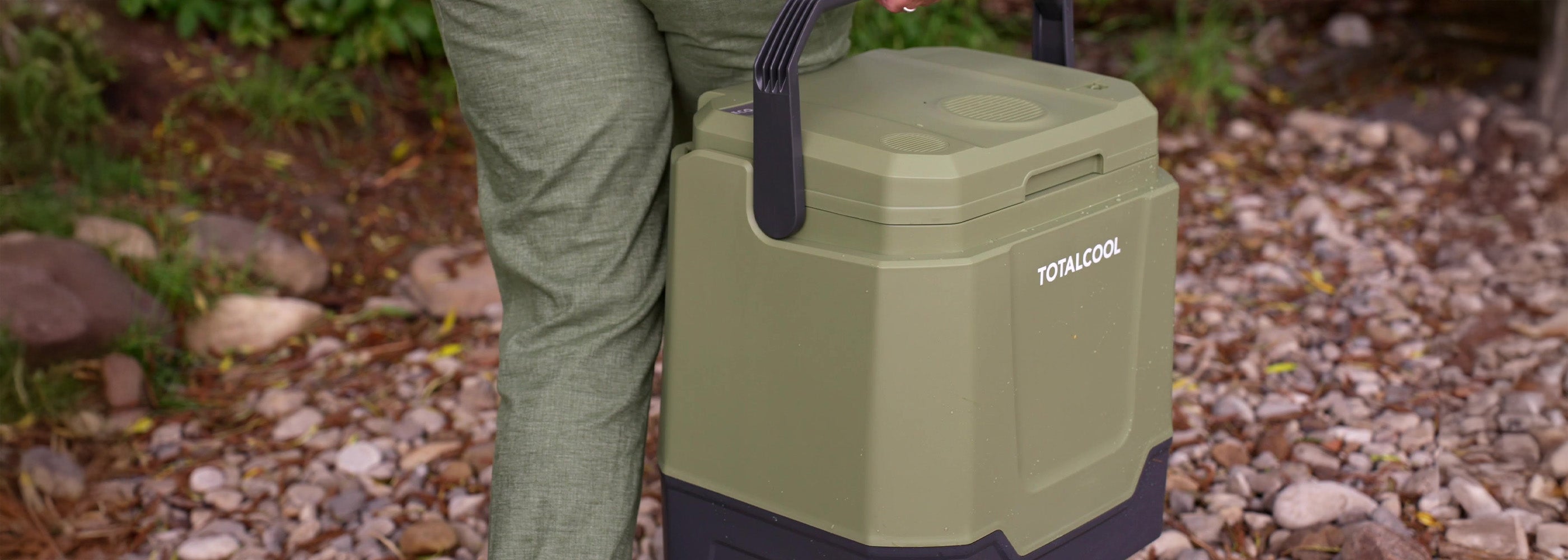 Image of the Eco-chill 33 camo green coolbox being carried along a forest path