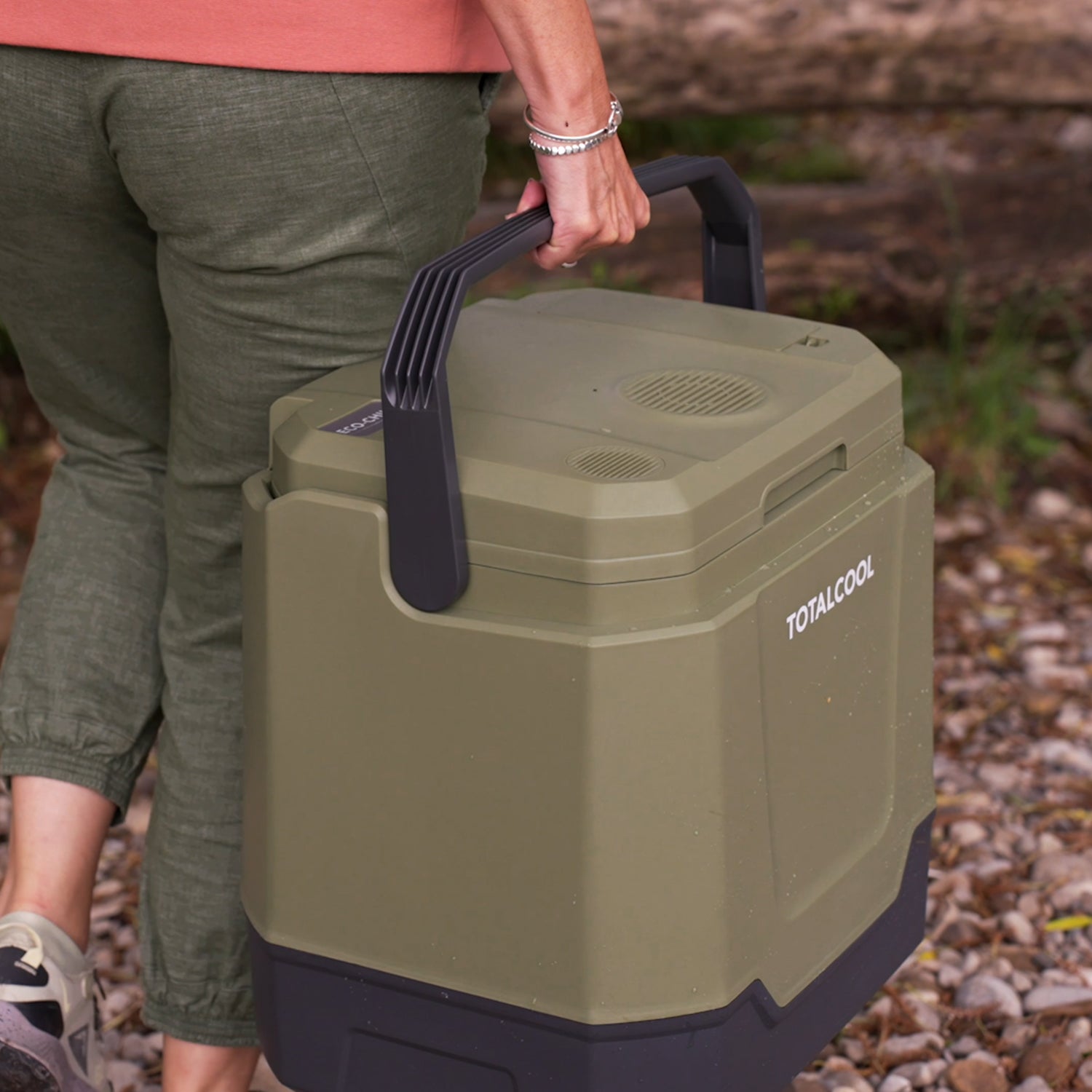 Image of a woman carrying the Eco-Chill 33 camo green cool box outdoors via the sturdy carrying handle