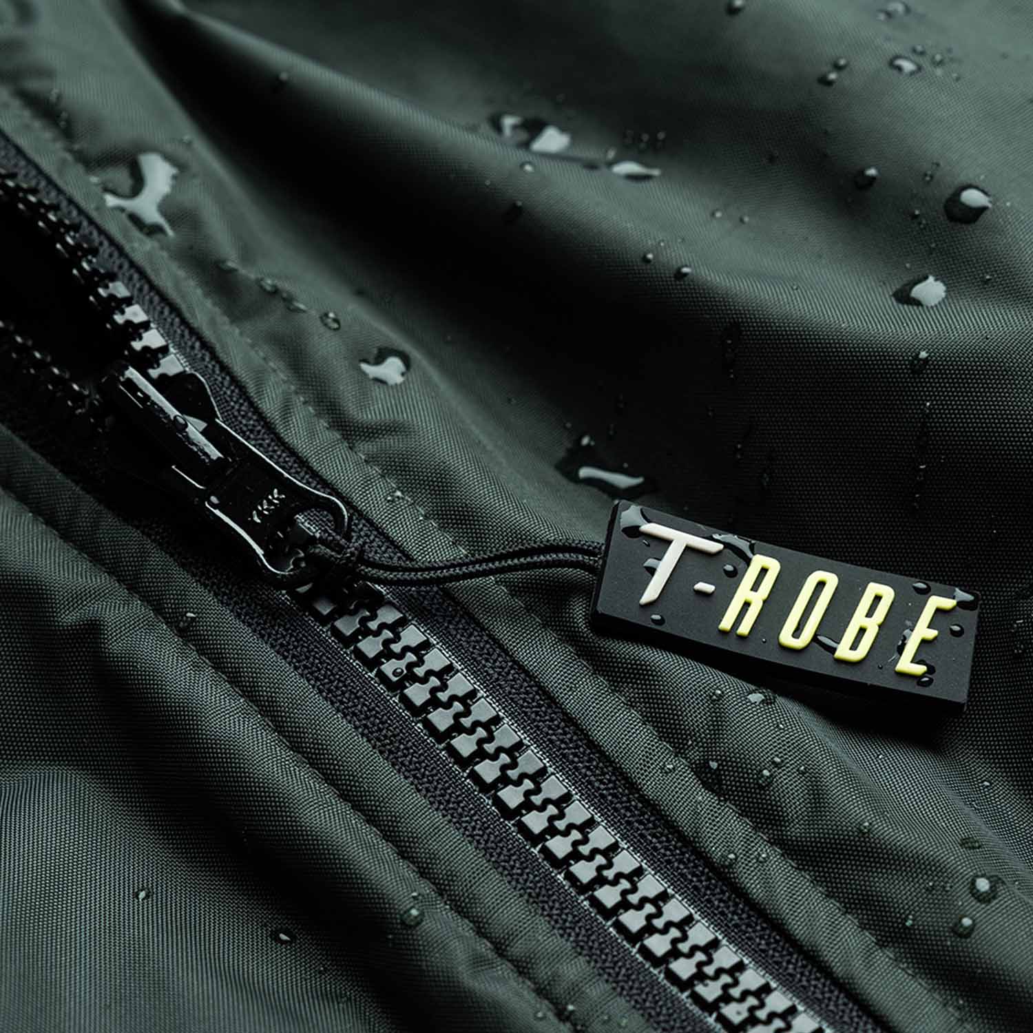 Image of water droplets on the surface of the green T-Robe showcasing the waterproof capabilities