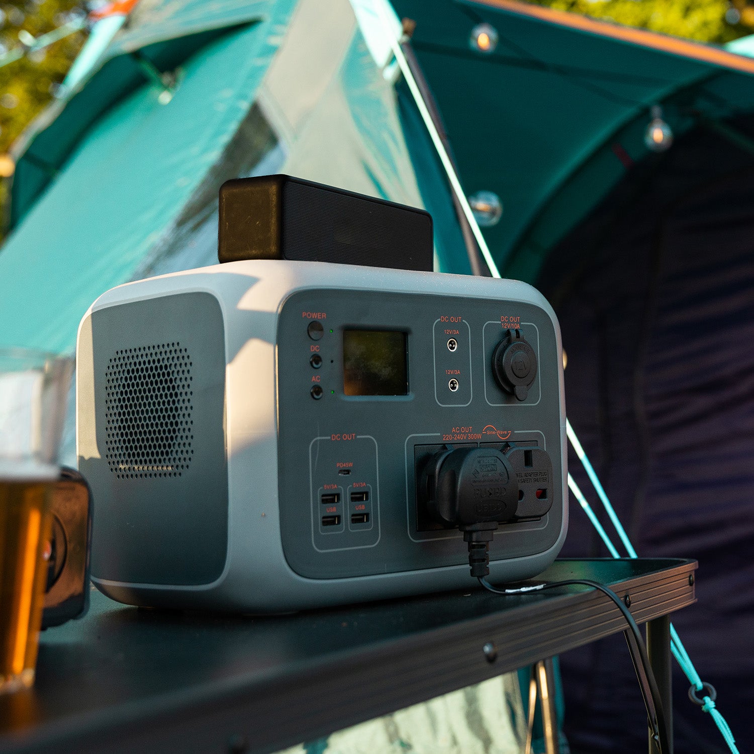 Image of the TP500 on a table outside of a tent powering a device via AC output